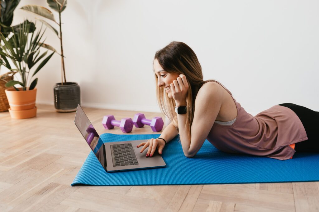 Kvinde på yogamåtte med computer
