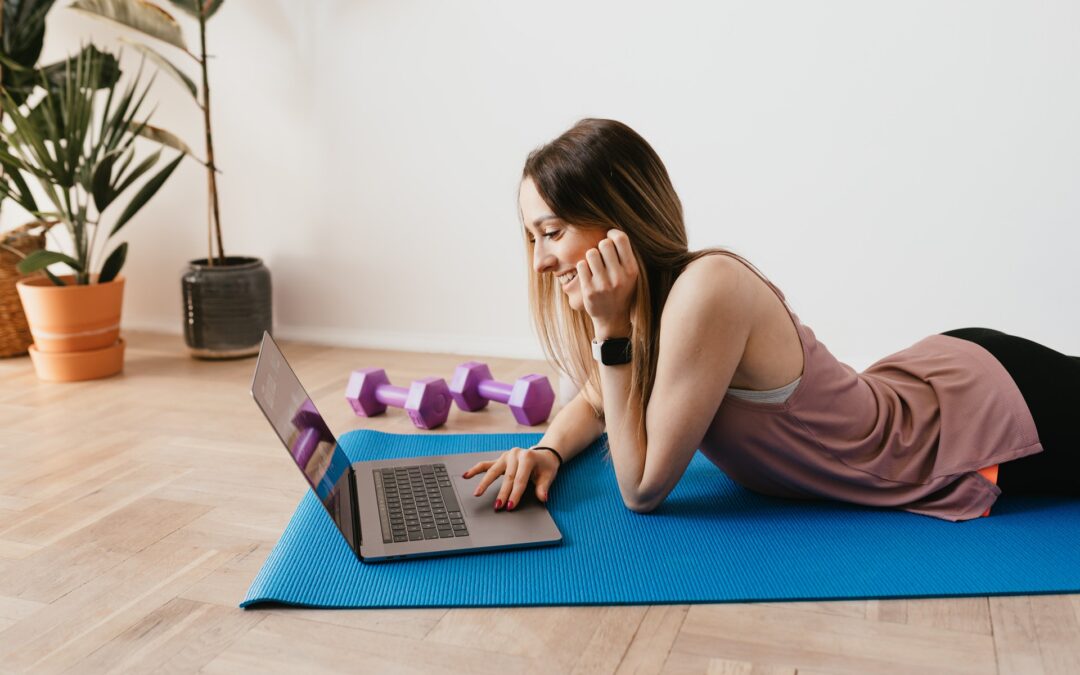 Kvinde på yogamåtte med computer